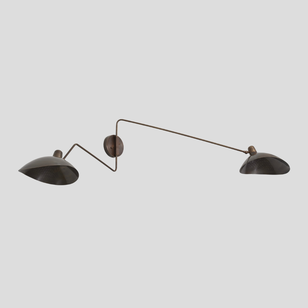 modern wall lamp with a double brass swing arm on gray background