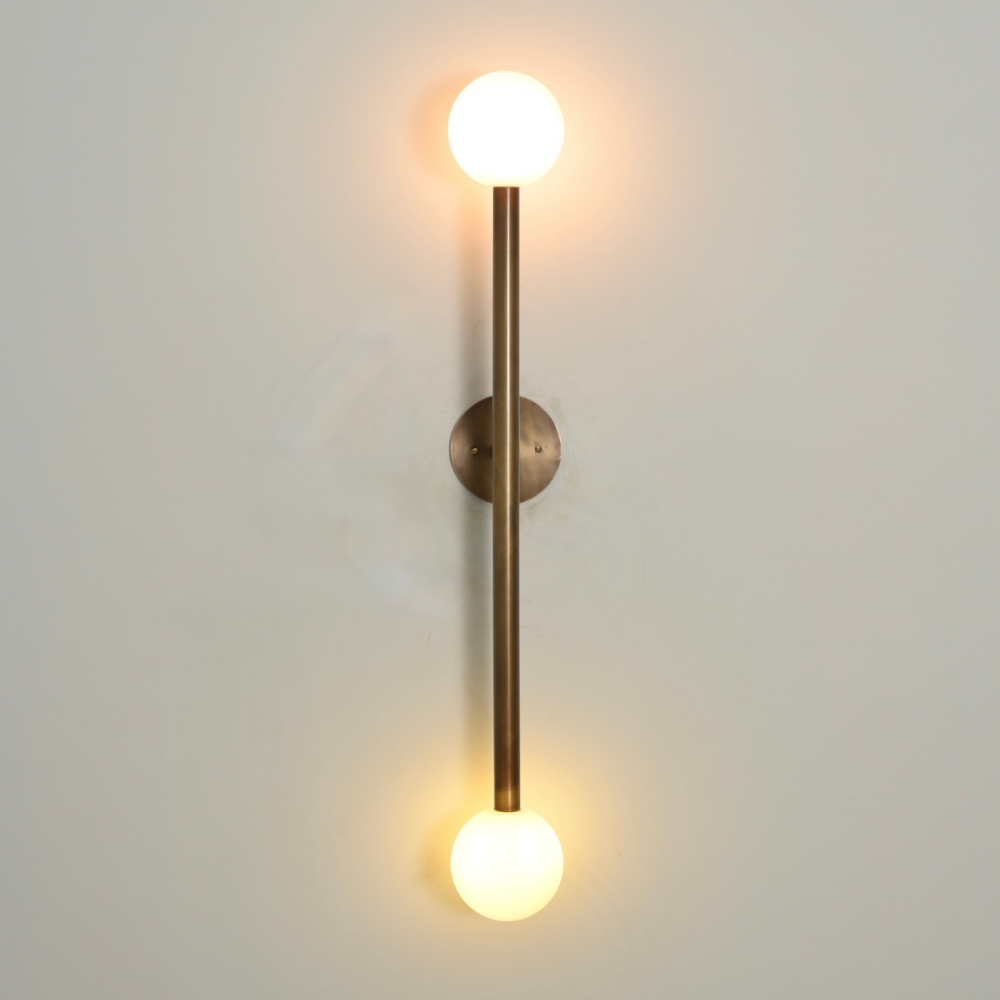 Mid century double brass globe wall sconce on a gray background