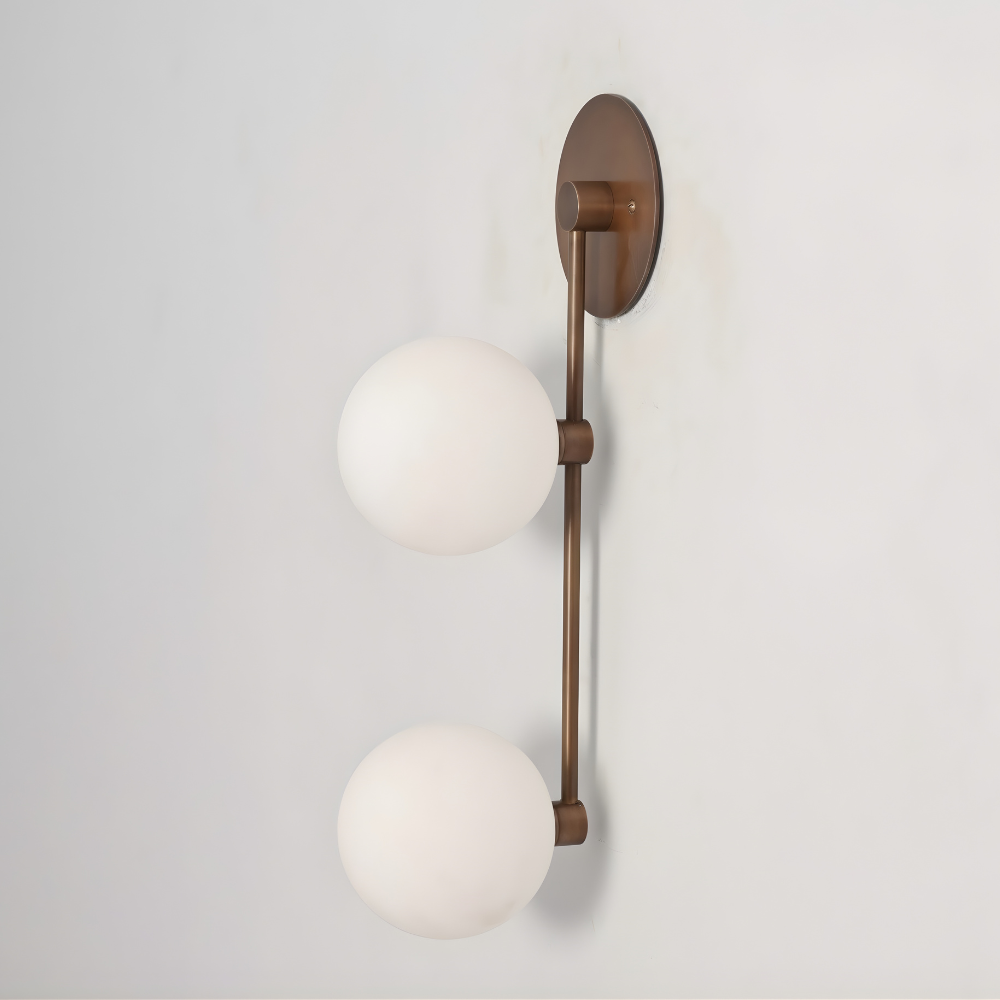 Wall-mounted light fixture with two white spherical lights on a plain background