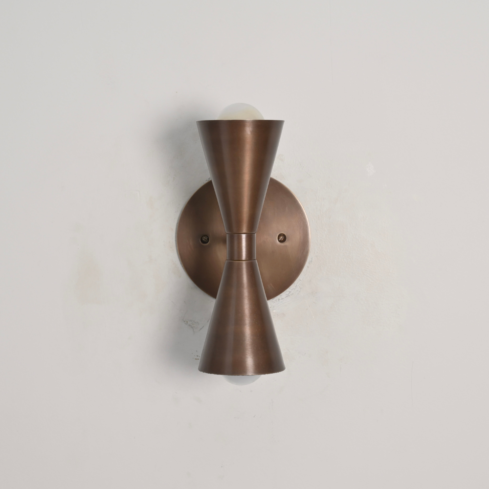 Modern double brass globe wall sconce with dual cone design on a gray wall by LightCove 