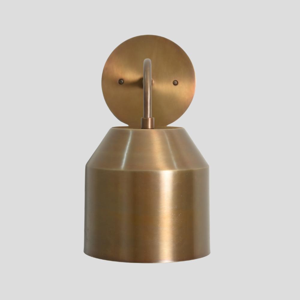Brass wall sconce on a light gray background