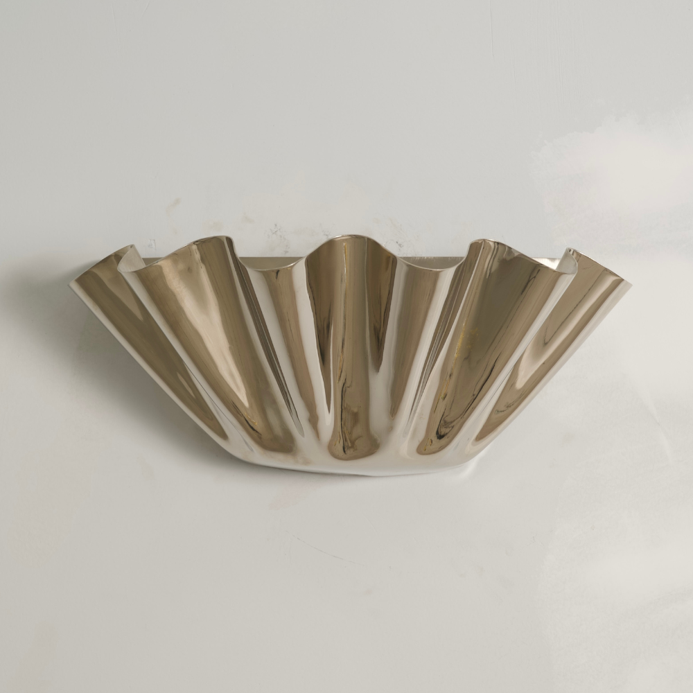 Polished brass petal wall sconce, in a modern mid century design in a gray background