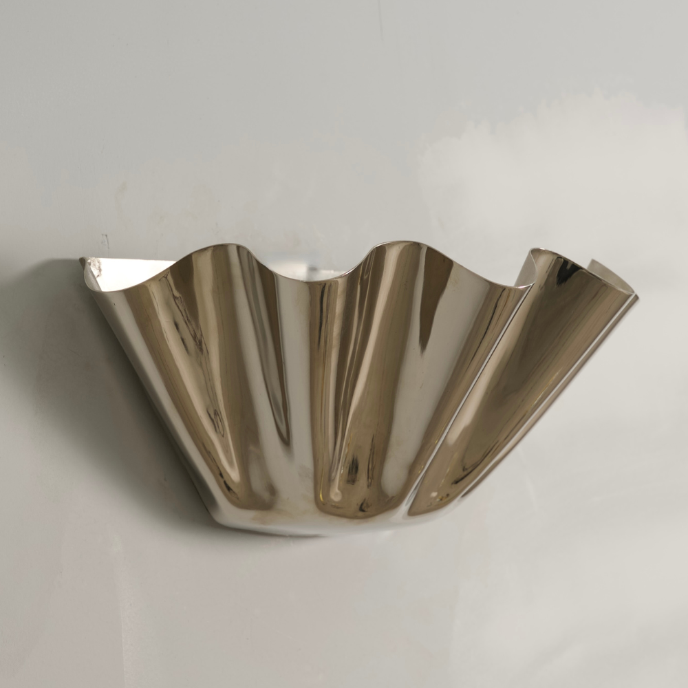 Brass Flower with a cut shade sconce on a gray background
