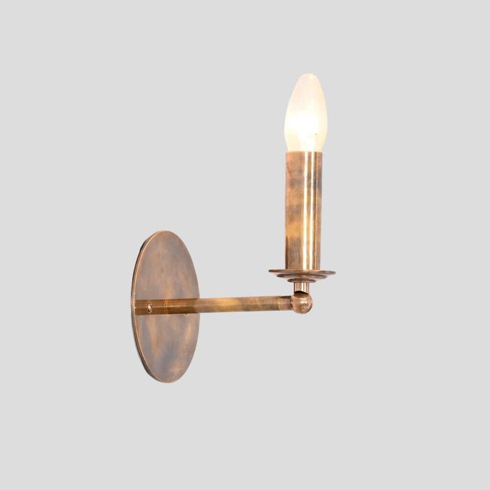 A mid century articulable brass wall sconce on a gray background, a pure metal piece handcrafted by LightCove 