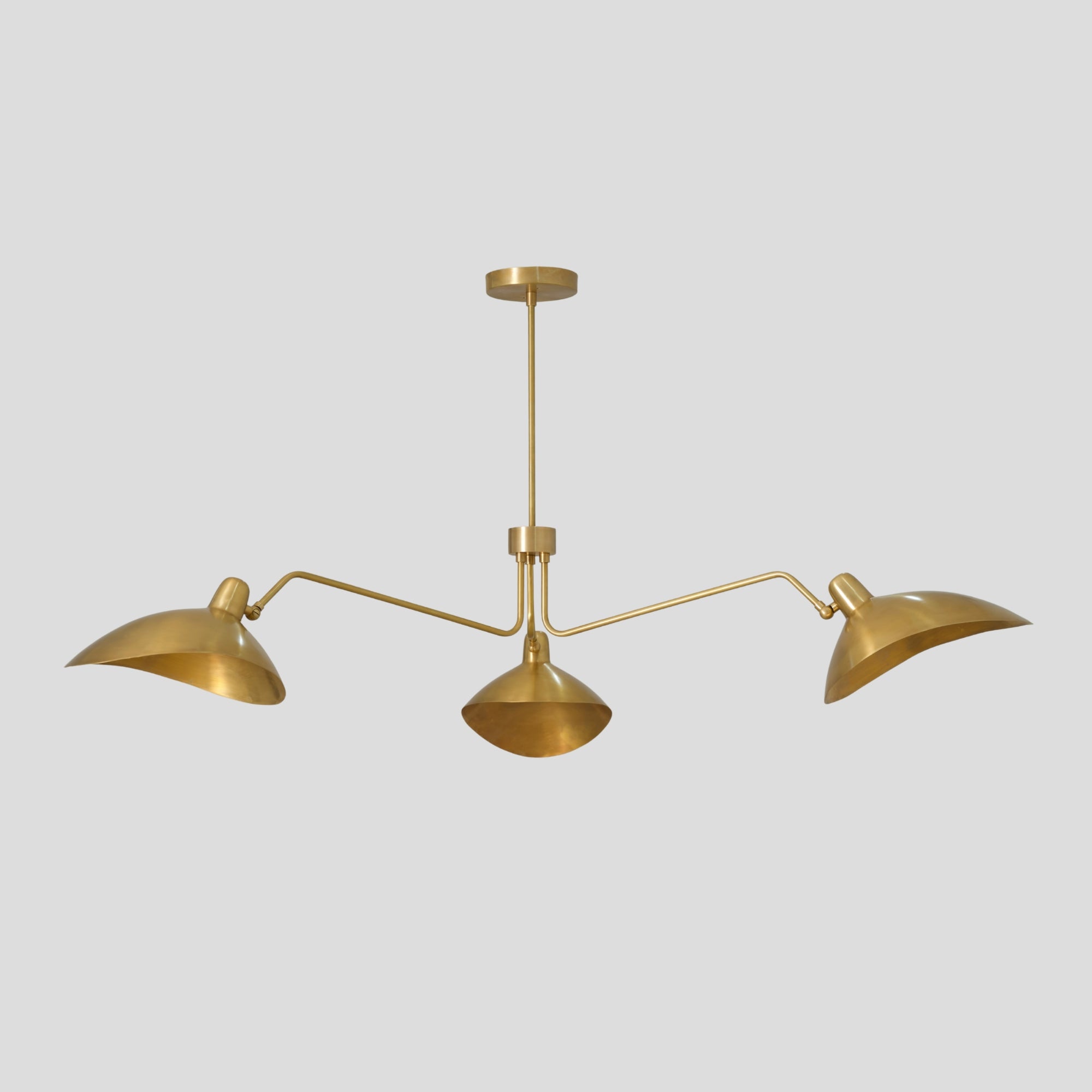 Brass pendant light with three arms on a gray background