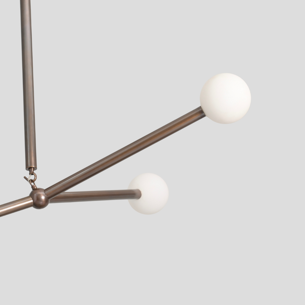 Close up on the brass frosted glass globe of a modern balanced chandelier 