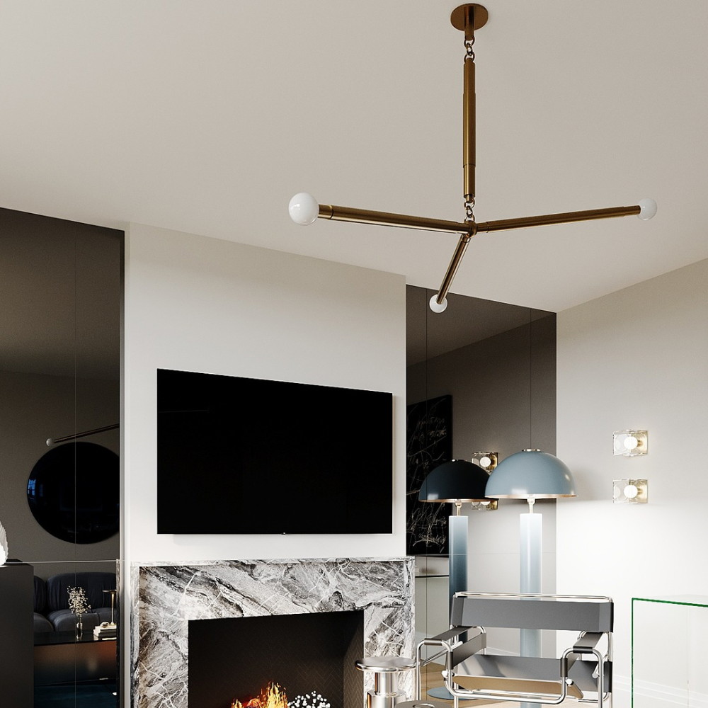 A modern ceiling light with a triple brass arm glass globe in a modern living room