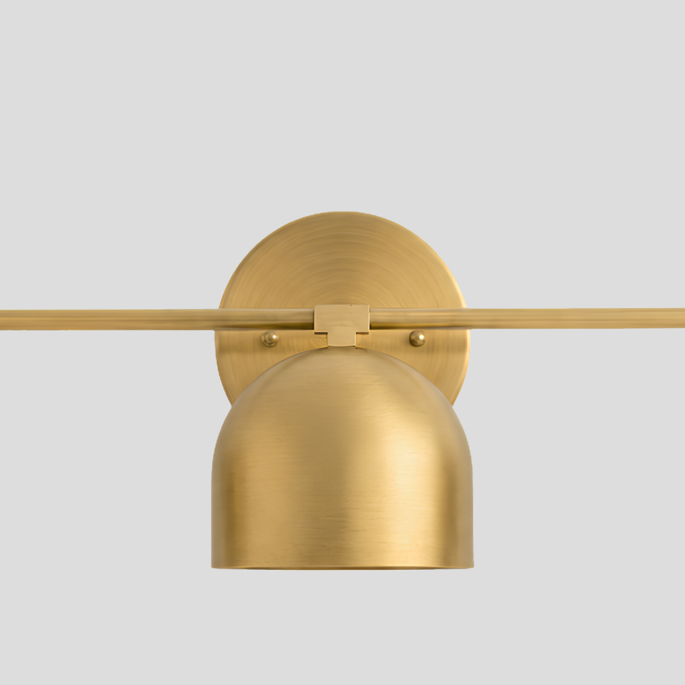 Close-up detail view of Triple Brass Dome Sconce - Mid Century Linear Arm Vanity Light showing dome shade, horizontal bar arm and brass canopy backplate.