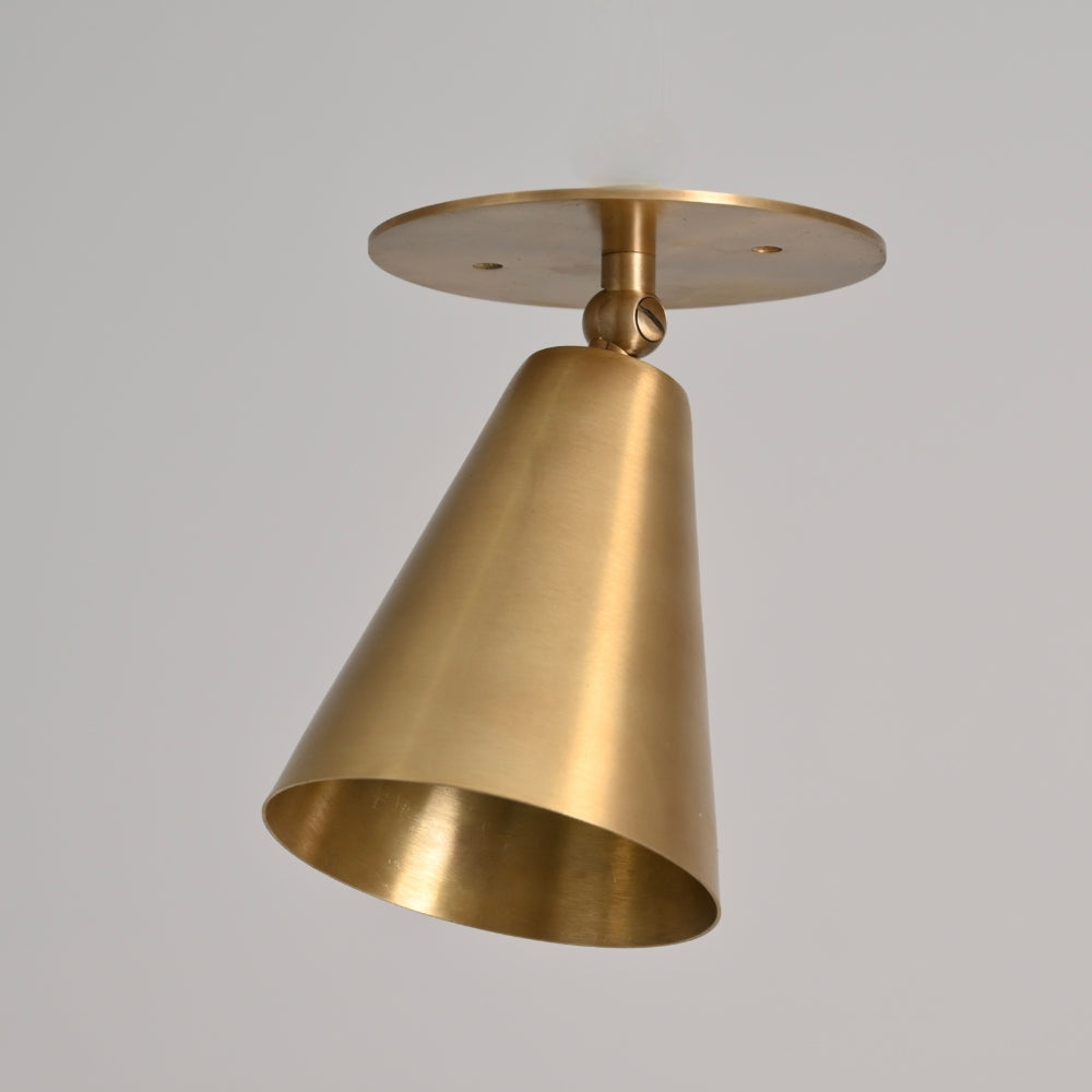 modern brass cone ceiling light on a gray background 