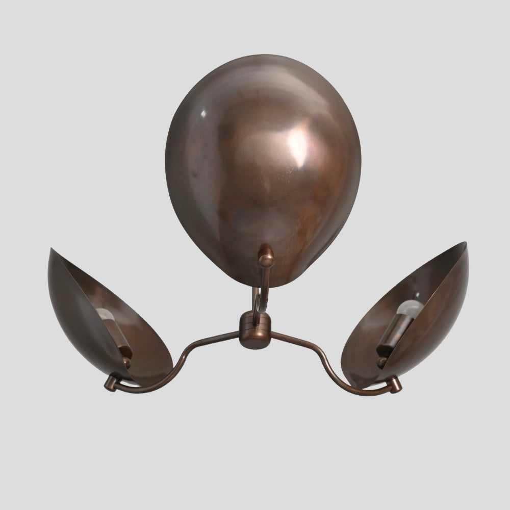 Brass ceiling light fixture with three curved shade on a gray background