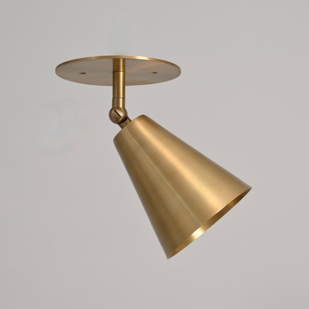 Vintage pure raw brass adjustable cone wall sconce on a gray background. 